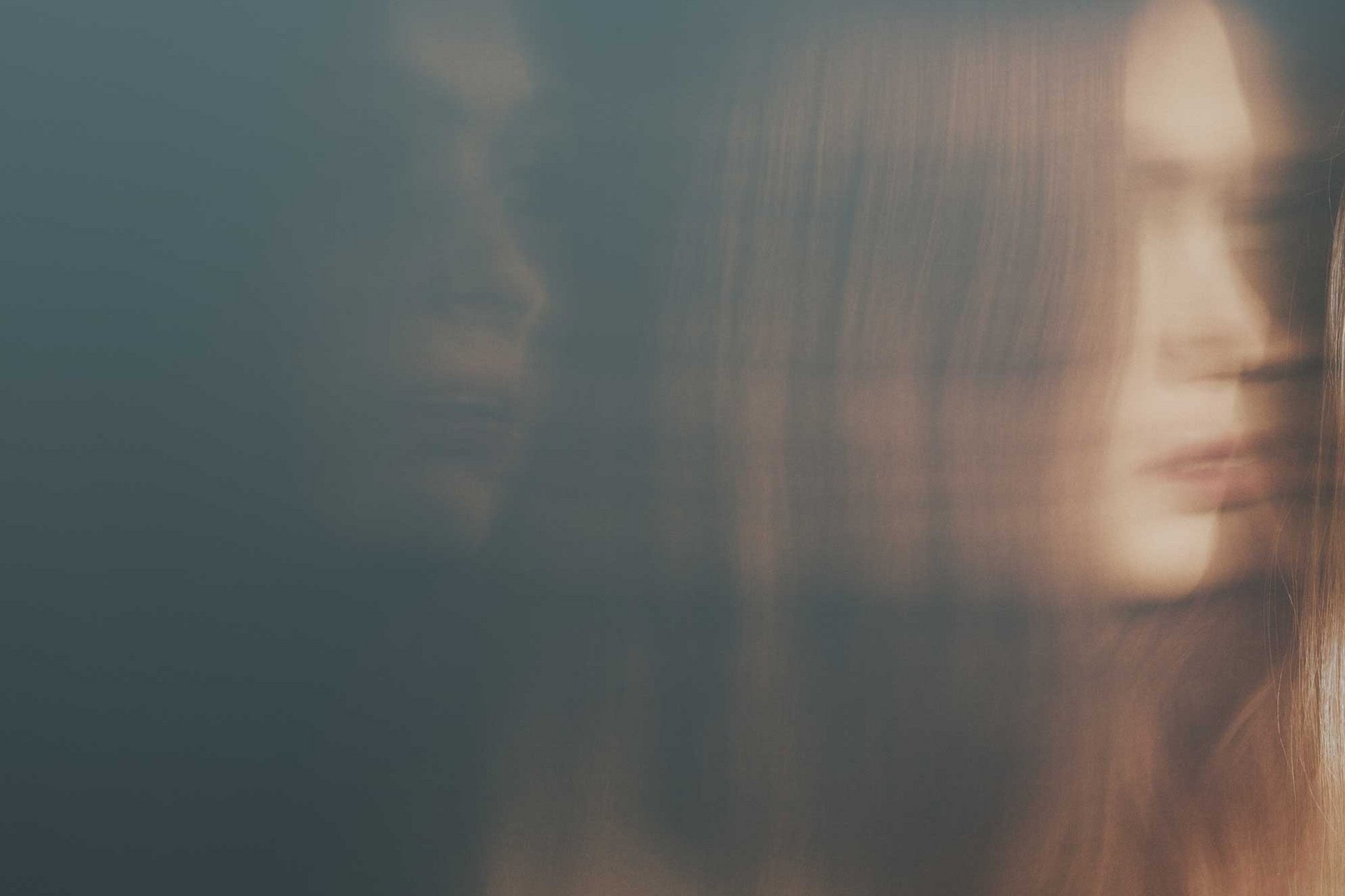  Ein verschwommenes Bild einer jungen Frau, im Hintergrund ist ihr Schatten zu sehen