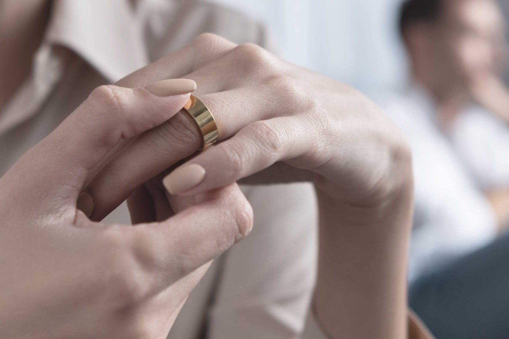 Frau zieht sich Ehering vom Finger, um eine eheliche Krise zu verdeutlichen