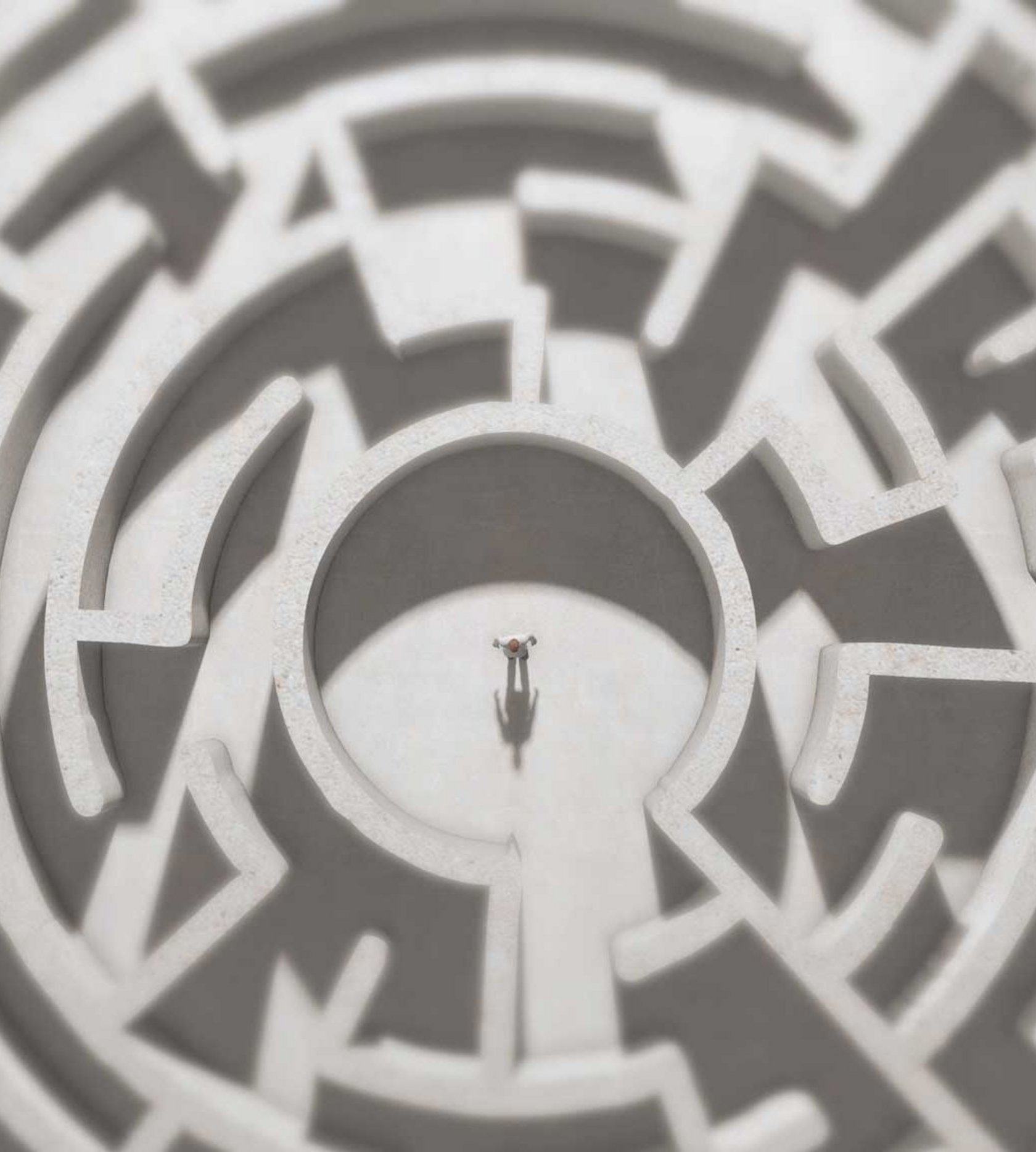 Eine Person steht Mitten in einem Labyrinth.