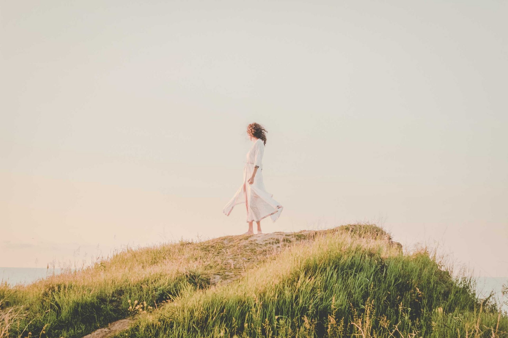 Eine Frau steht auf einem Hügel.