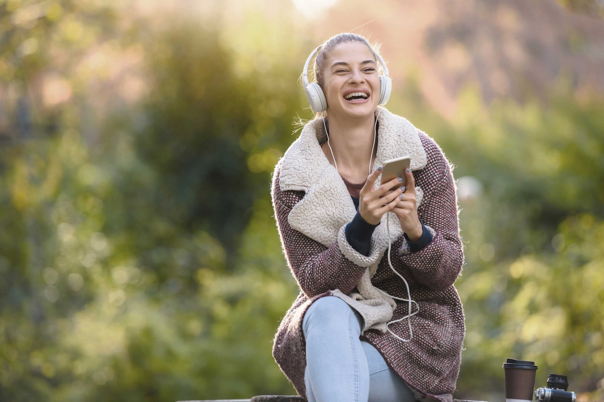 Eine Frau hört Musik und lacht.