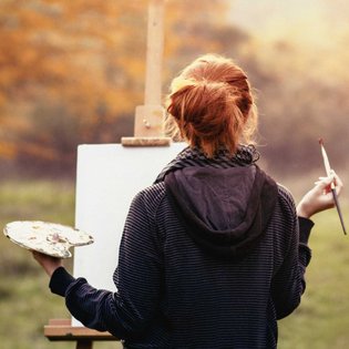 Eine Frau zeichnet ein Bild in der Natur.