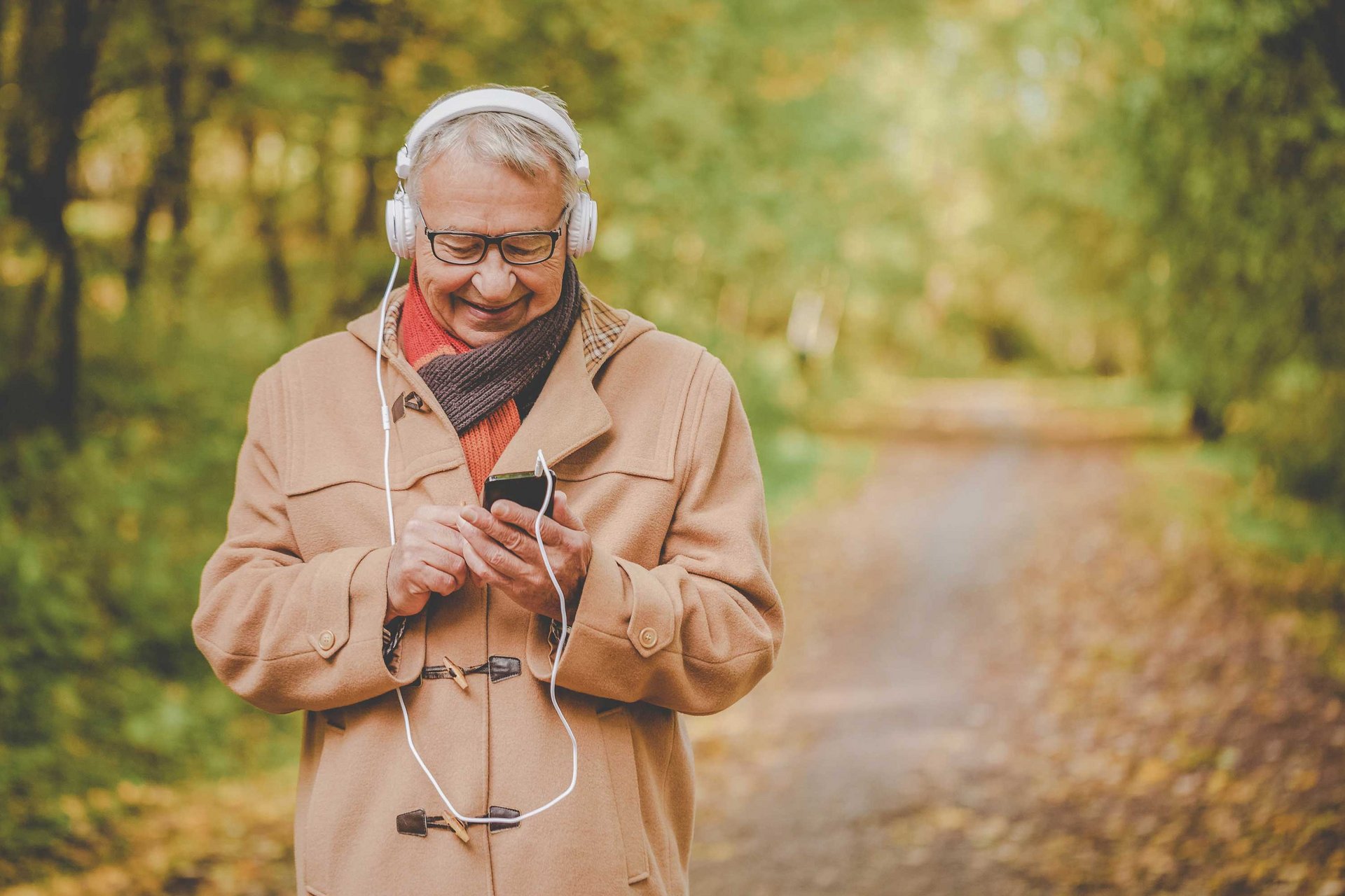 Eine ältere Person geht Musik hörend spazieren.