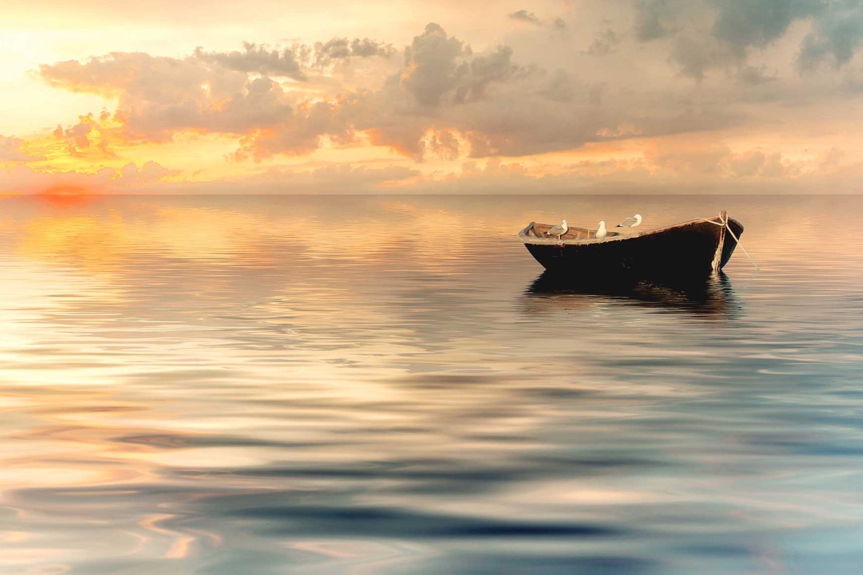Ein Boot treibt auf dem ruhigen Meer im Sonnenuntergang.