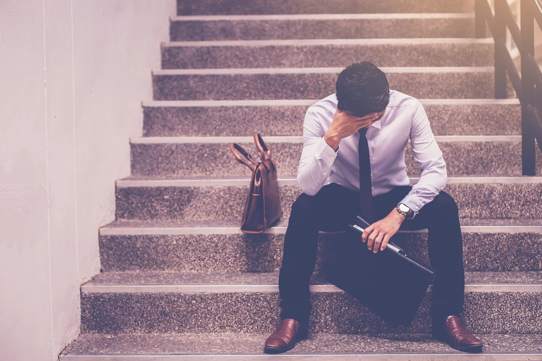 Manager-sitzt-niedergeschlagen-auf-Treppe