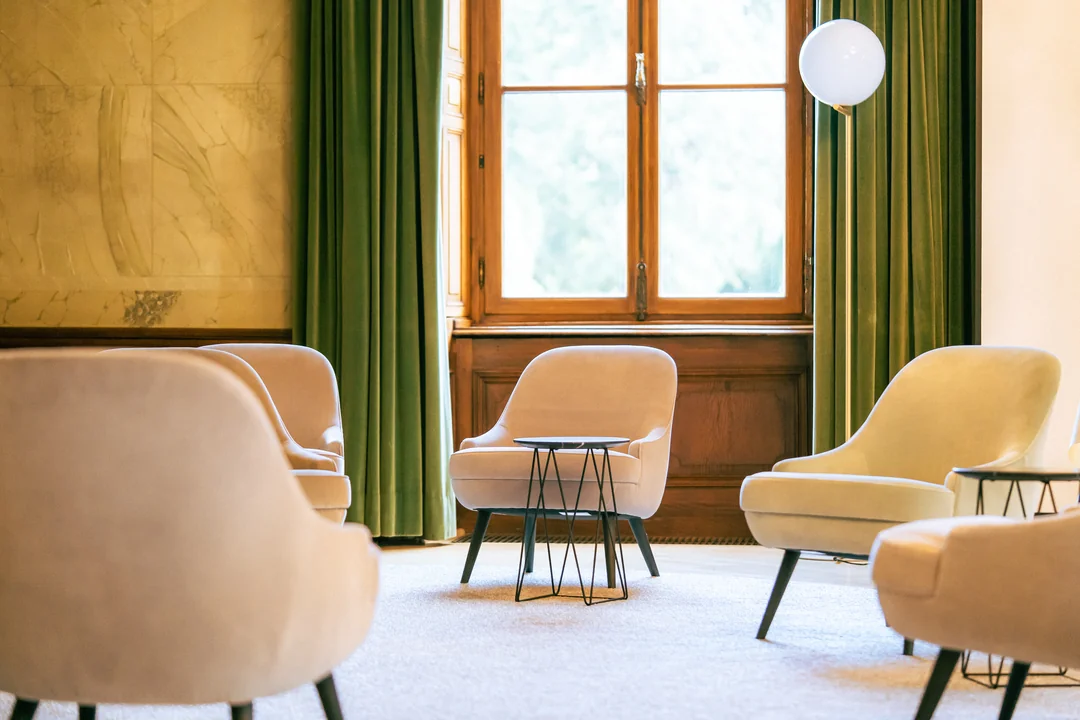 beige-sessel-gruene-vorhaenge-eleganter-salon