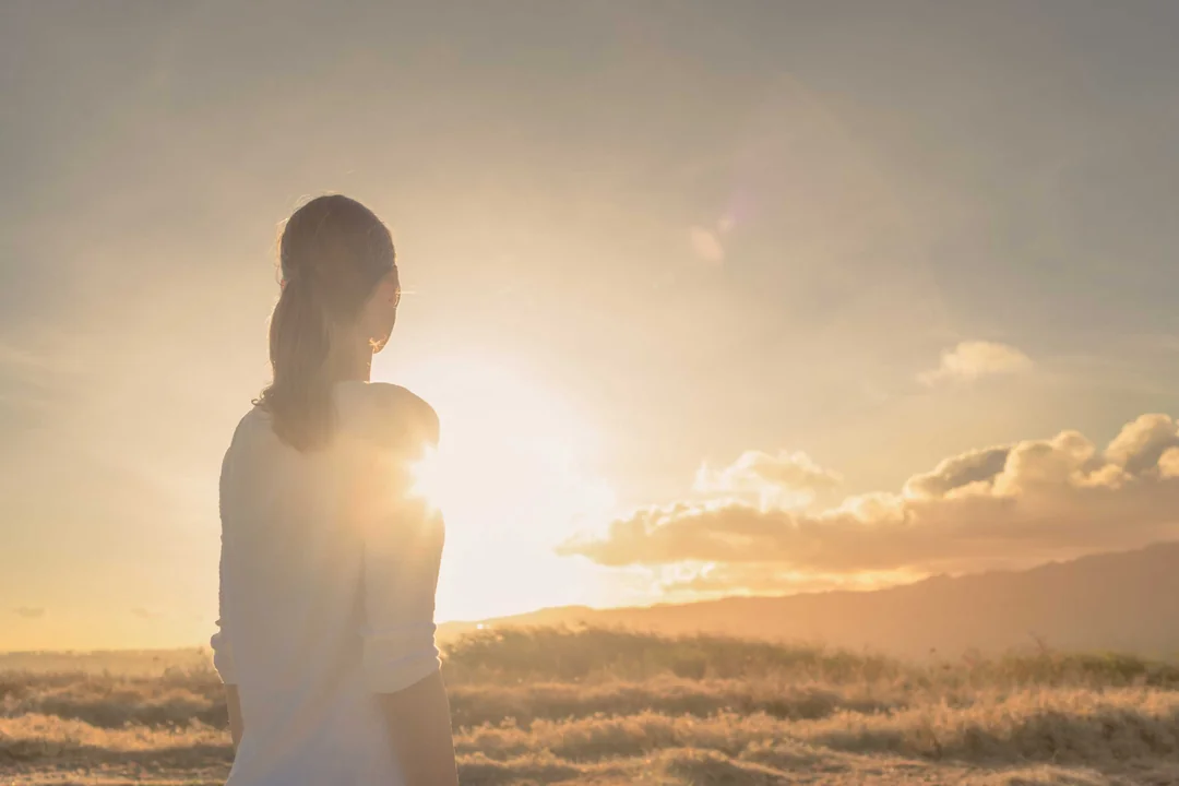 frau-steht-in-natur-und-schaut-in-ferne