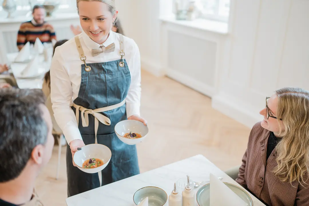 kellnerin-serviert-essen-restaurant-gaeste