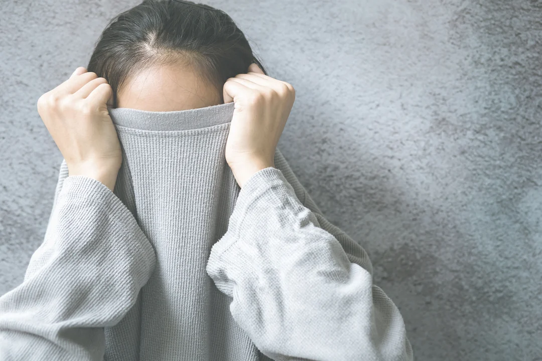 maedchen zieht pullover ueber kopf