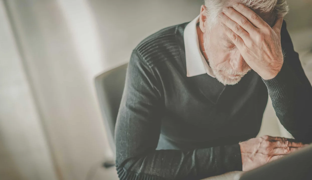 mann haelt sich gestresst den kopf
