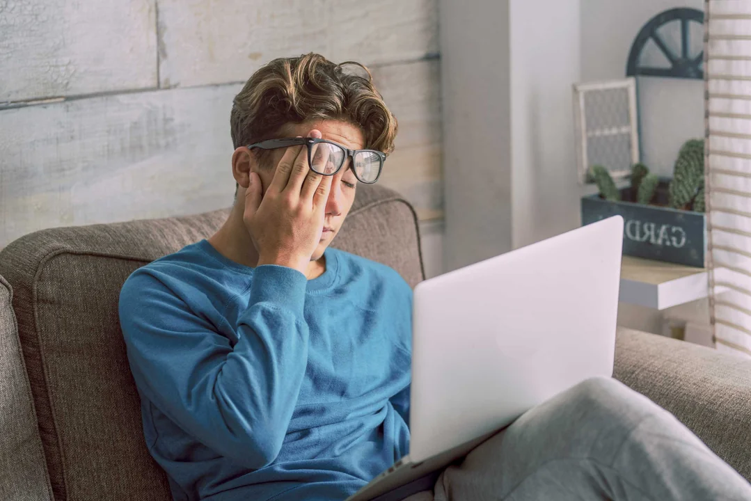 mann-reibt-sich-die-augen-mit-laptop