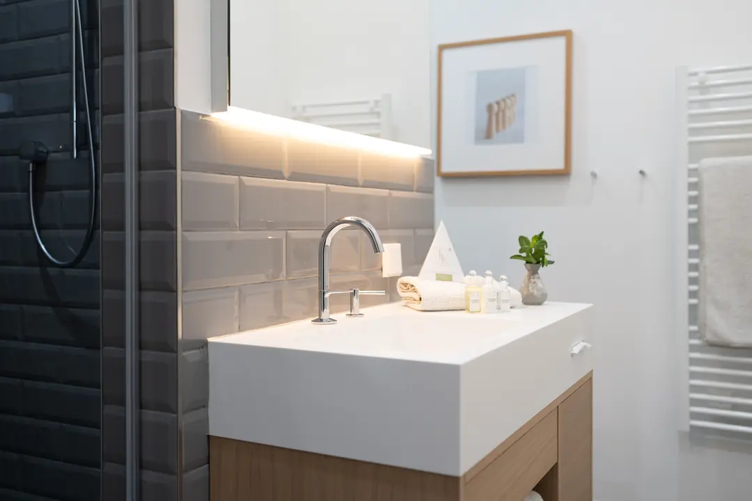 modernes-badezimmer-weisser-waschtisch-graue-fliesen-dusche-2