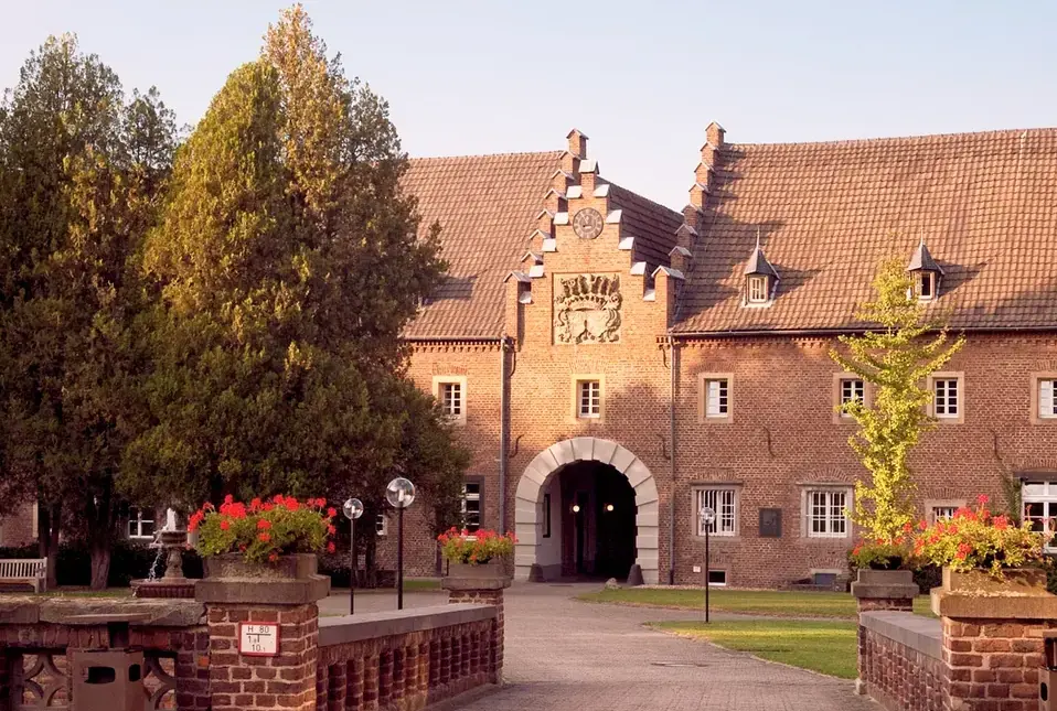 historisches backsteintor schloss innenhof blumen baeume e1781763007282