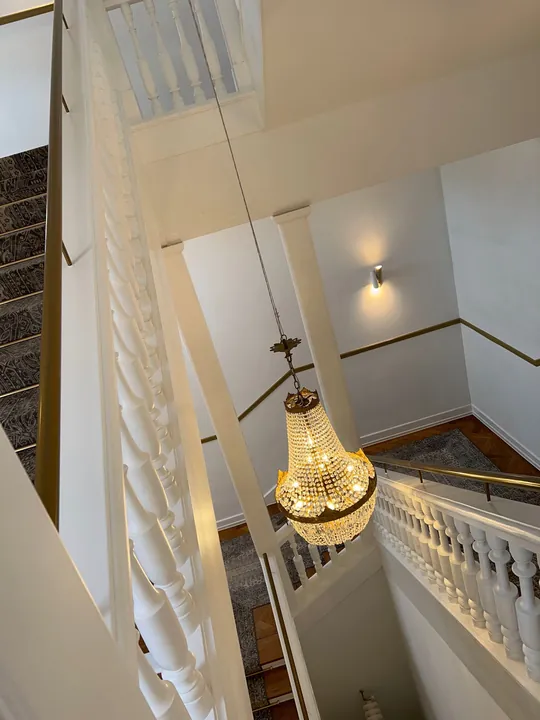 kristall kronleuchter elegantes treppenhaus weisse balustraden goldene akzente