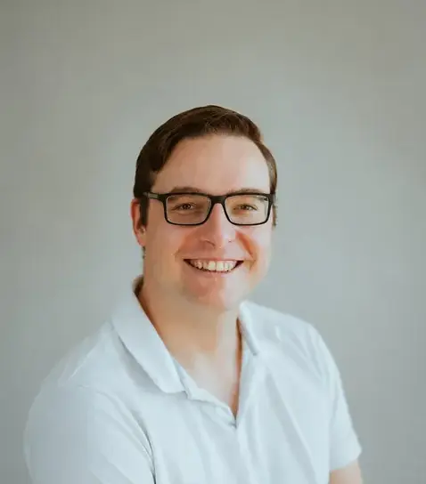 mann-weisses-poloshirt-brille-laecheln-portrait