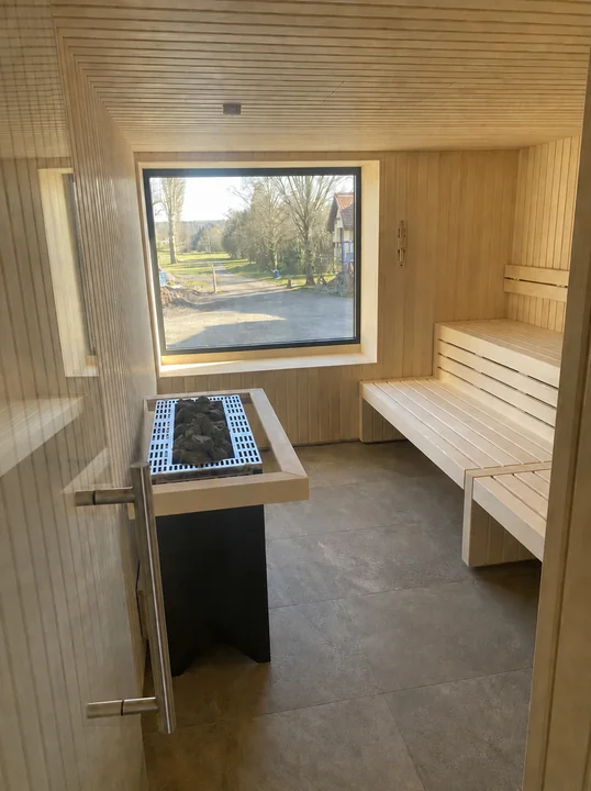 moderne sauna holzverkleidung saunaofen panoramafenster wellnessbereich