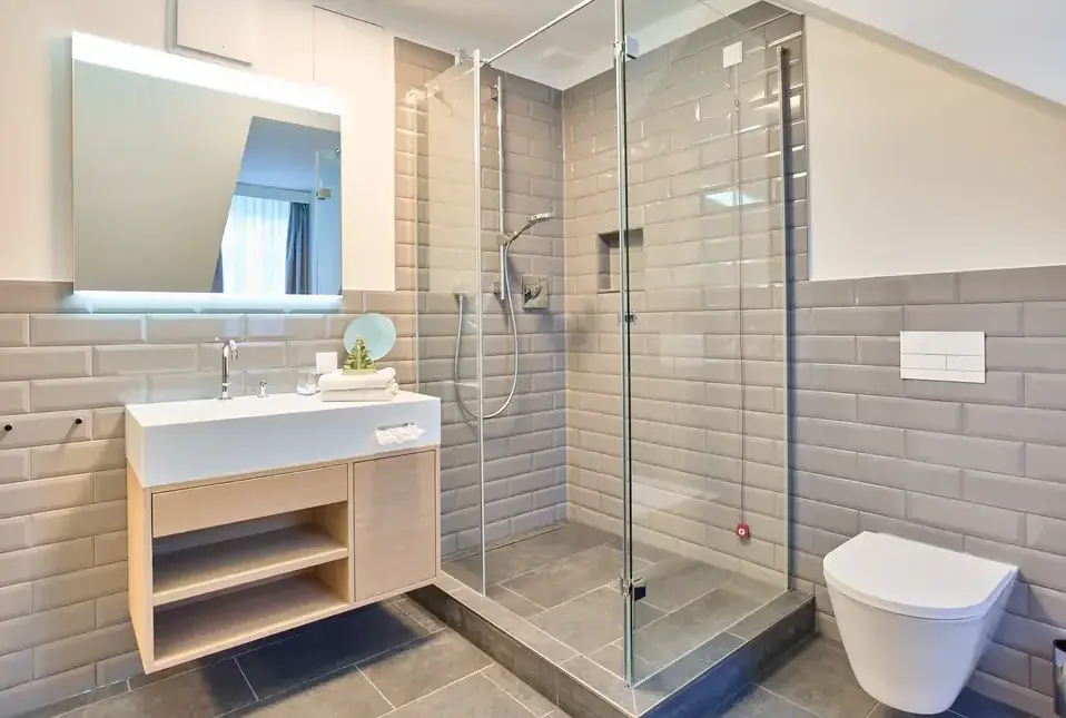 modernes badezimmer glasdusche weisser waschtisch graue fliesen e1782805015571