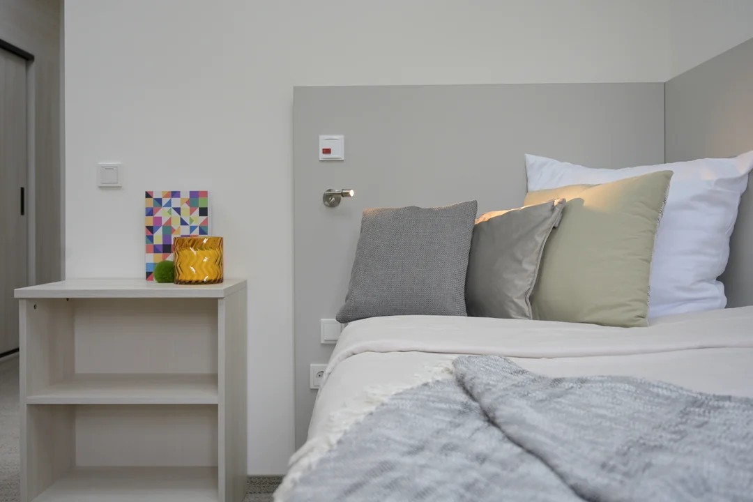 modernes schlafzimmer graues bett weisse kissen nachttisch