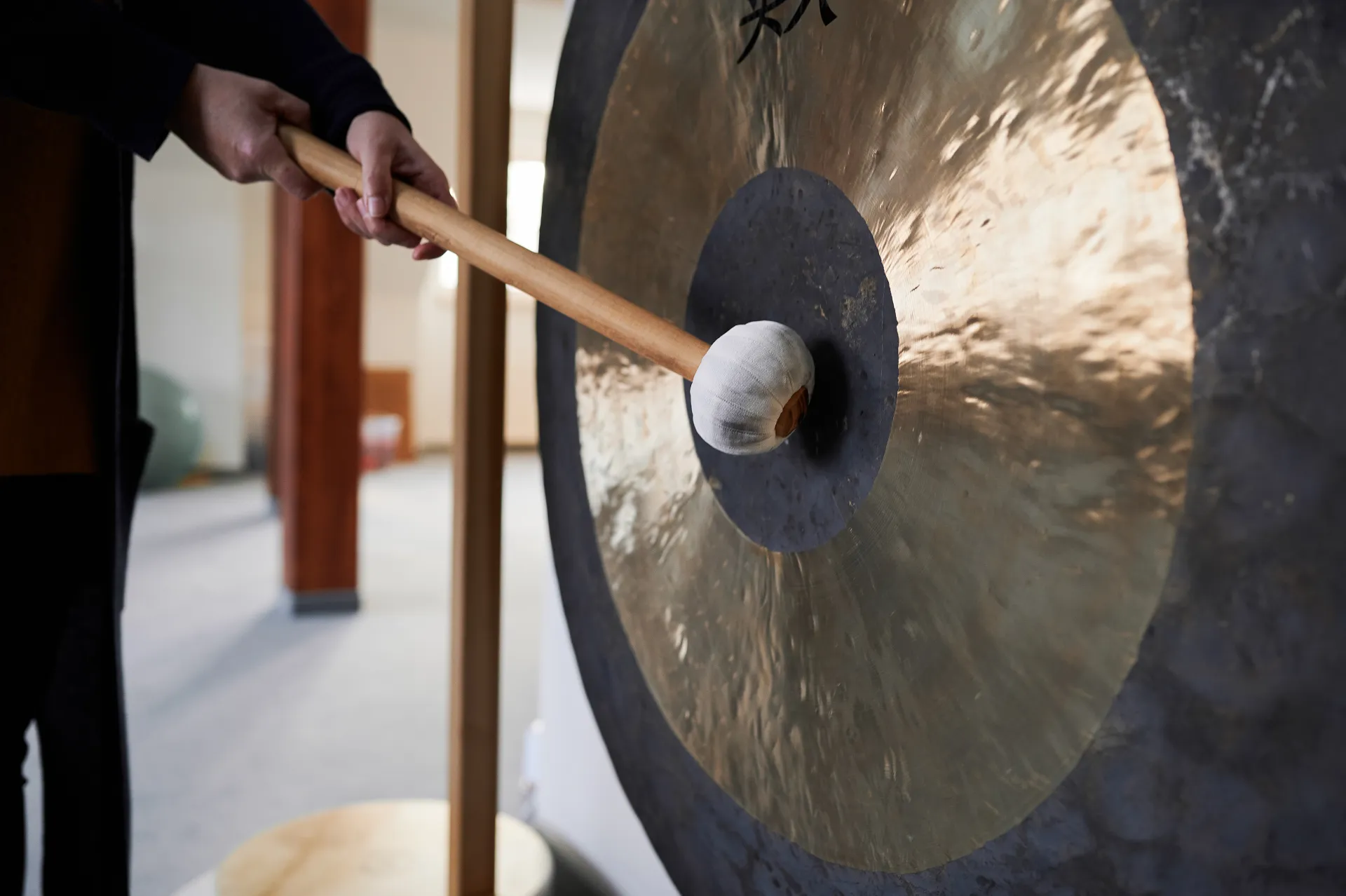 Musiktherapie: Anschlagen eines großen Gongs im Therapieraum