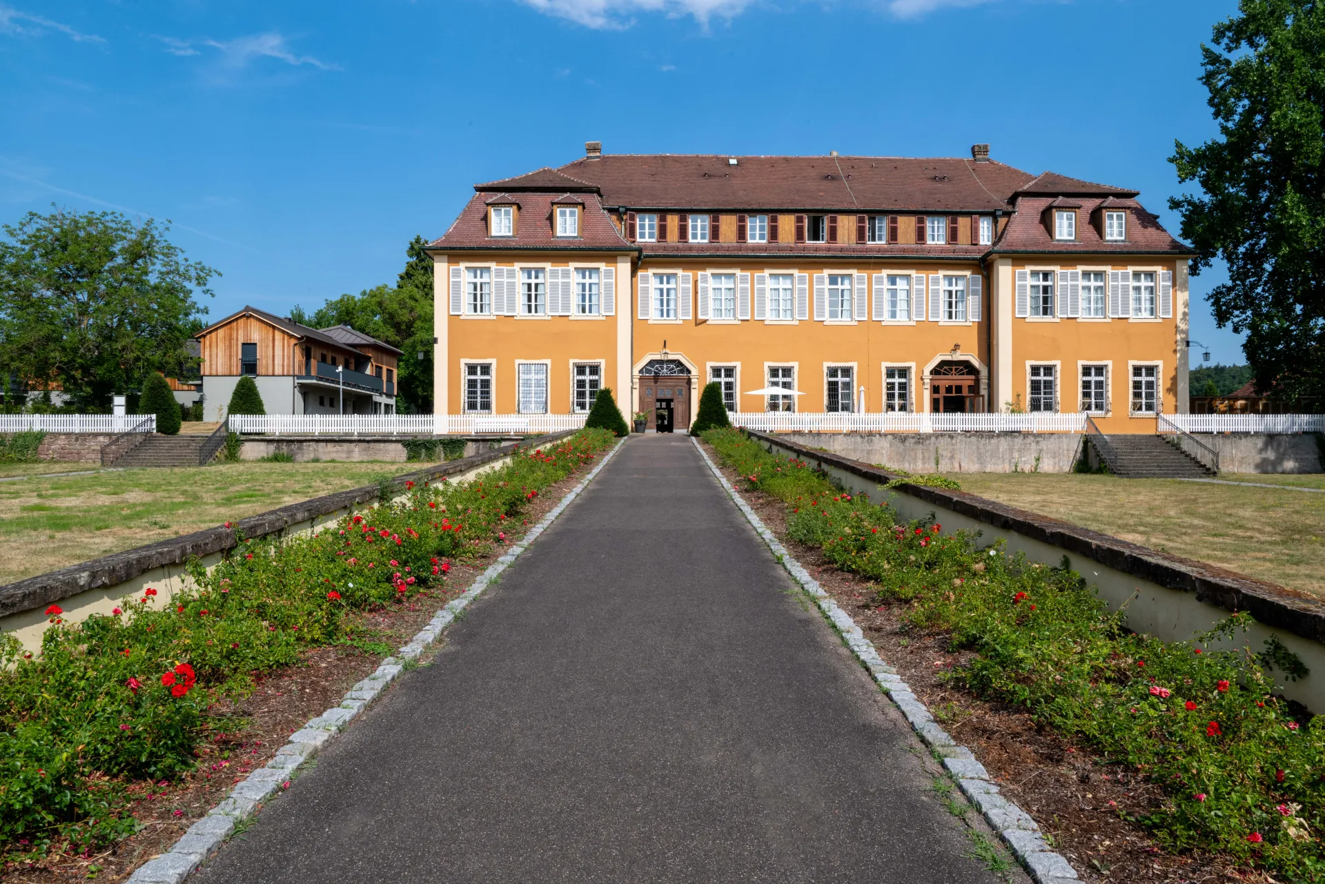 Weg zwischen Rosenbeeten zum Eingang von Schloss Freudental